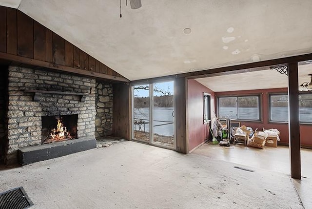 unfurnished living room featuring visible vents, a fireplace, a ceiling fan, and lofted ceiling