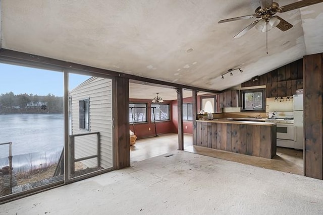 kitchen featuring a wealth of natural light, ceiling fan with notable chandelier, white appliances, and vaulted ceiling