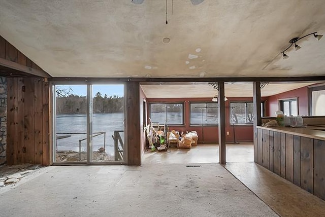 interior space featuring lofted ceiling, a ceiling fan, and a water view