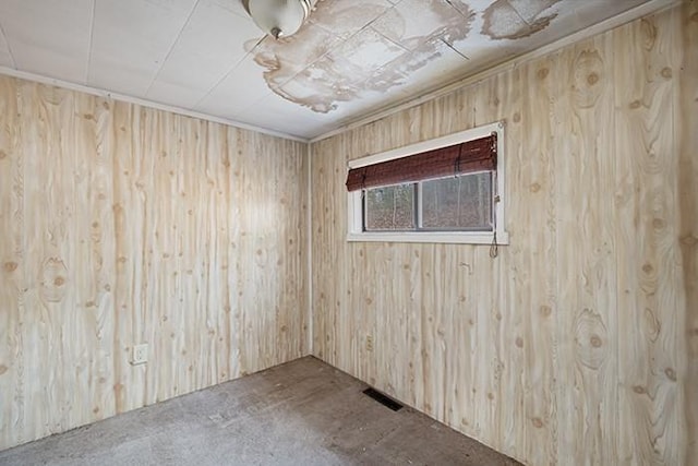 empty room featuring visible vents and wood walls