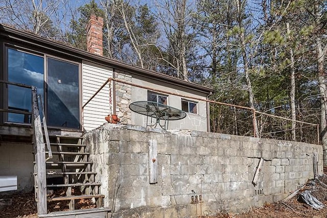 view of home's exterior featuring stairway and a chimney