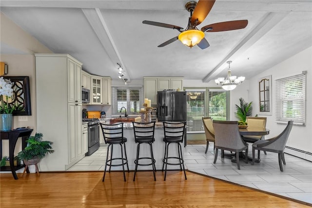 kitchen with beamed ceiling, black range with gas stovetop, stainless steel microwave, a kitchen breakfast bar, and refrigerator with ice dispenser