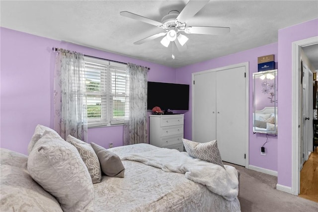 bedroom with carpet flooring, a ceiling fan, baseboards, and a closet