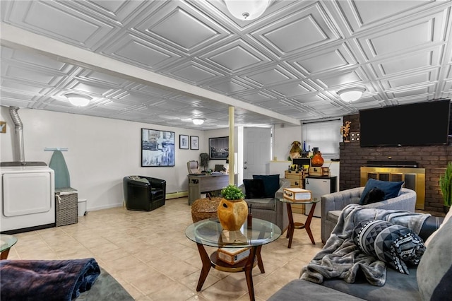 living room with light tile patterned floors, baseboards, washer / dryer, a fireplace, and an ornate ceiling