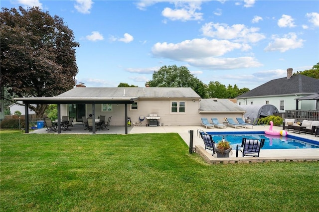 back of property with an outdoor pool, a patio, a yard, and fence