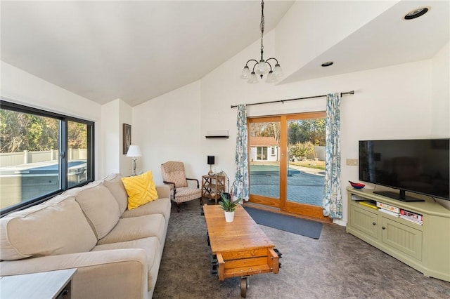 carpeted living room with a chandelier and high vaulted ceiling