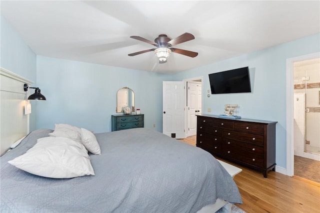 bedroom featuring wood finished floors, baseboards, ensuite bathroom, and ceiling fan