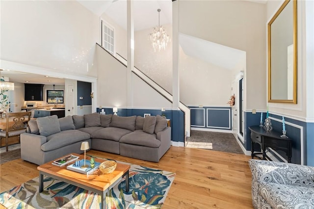 living room with a notable chandelier, a high ceiling, and wood finished floors