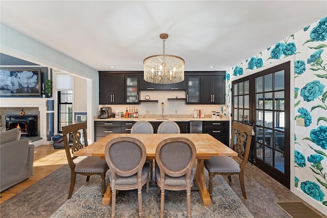 dining area featuring a wealth of natural light, visible vents, a lit fireplace, and a chandelier