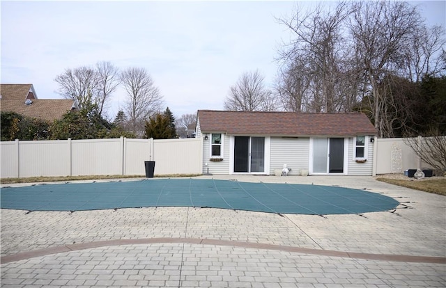 view of swimming pool featuring a fenced backyard, a patio, a fenced in pool, and an outdoor structure