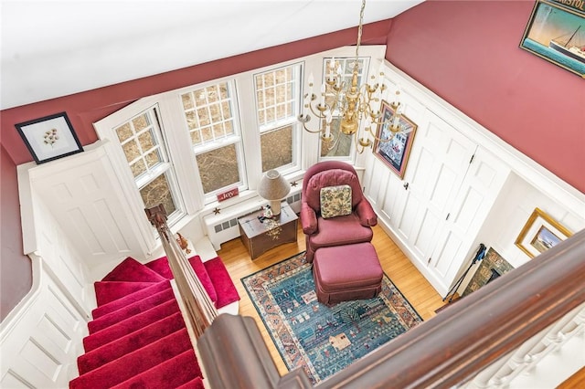 sitting room featuring an inviting chandelier, stairs, and wood finished floors