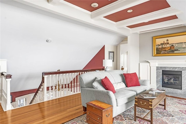 living area featuring a fireplace, wood finished floors, and vaulted ceiling with beams