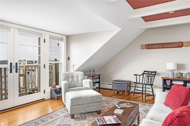 living area featuring lofted ceiling with beams, wood finished floors, a baseboard heating unit, and french doors