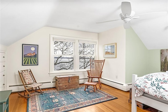 bedroom featuring baseboards, vaulted ceiling, a baseboard radiator, and wood finished floors