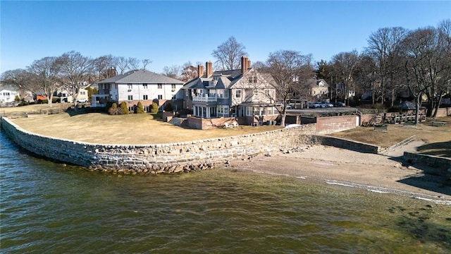 back of property with a residential view, a water view, and a chimney