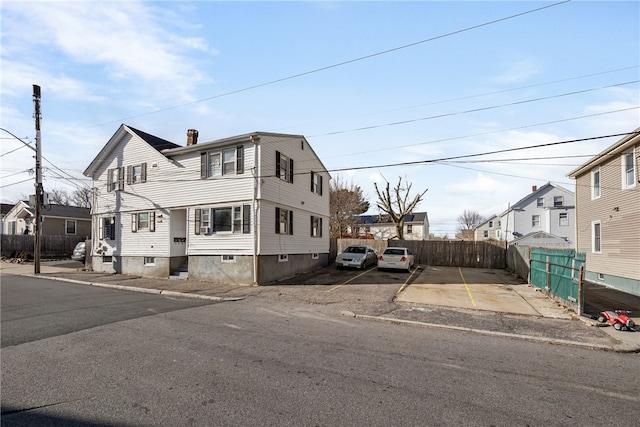 view of front of home with a chimney and fence