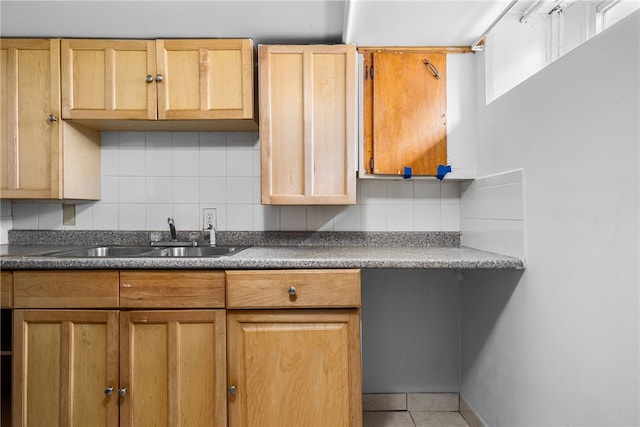 kitchen with tile patterned floors, dark countertops, tasteful backsplash, and a sink