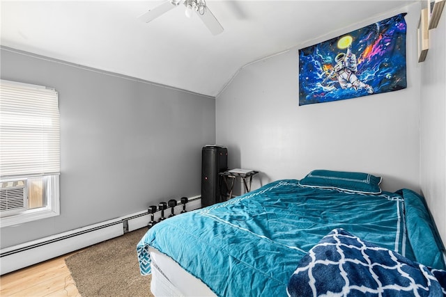 bedroom featuring a baseboard heating unit, lofted ceiling, wood finished floors, and ceiling fan