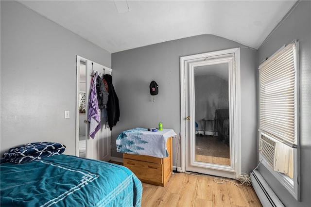 bedroom with a baseboard radiator, lofted ceiling, light wood-style flooring, ceiling fan, and a baseboard heating unit