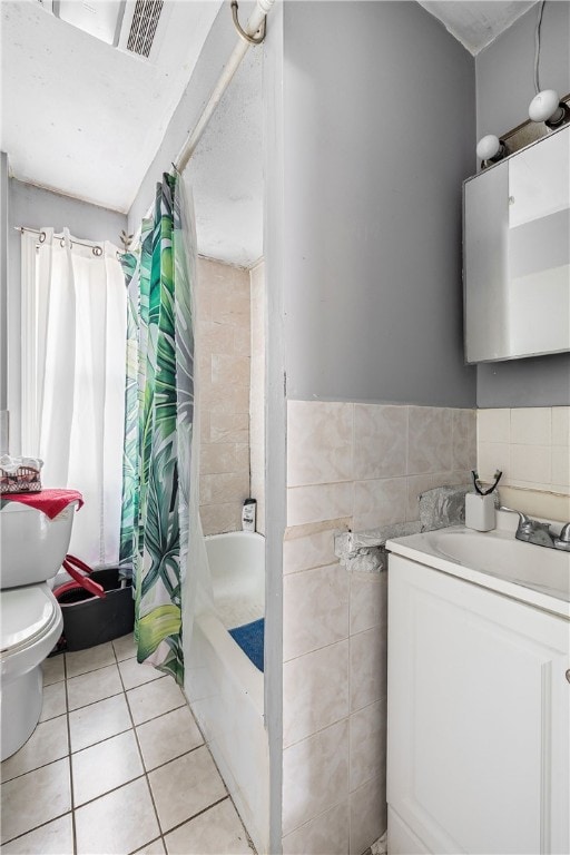 full bathroom featuring tile patterned floors, shower / bath combo with shower curtain, toilet, tile walls, and vanity