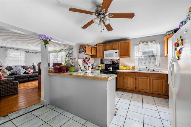 kitchen with light tile patterned floors, white appliances, and light countertops