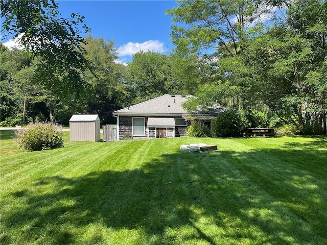 view of yard featuring a storage shed, fence, and an outdoor structure