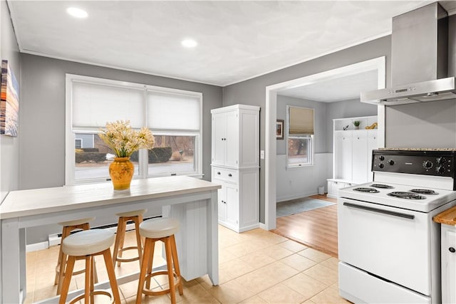 kitchen featuring a wealth of natural light, wall chimney range hood, white cabinetry, and white range with electric stovetop