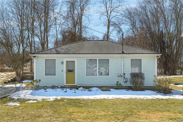 view of front of home with a yard and roof with shingles