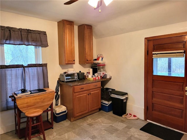 141 Centennial St, Burrillville, RI 02859 - kitchen featuring ceiling fan, dark countertops, brown cabinetry, and vaulted ceiling