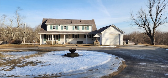 view of front of home featuring a chimney, covered porch, driveway, and an attached garage