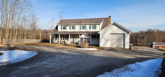 view of front of home with fence, a porch, a chimney, a garage, and aphalt driveway