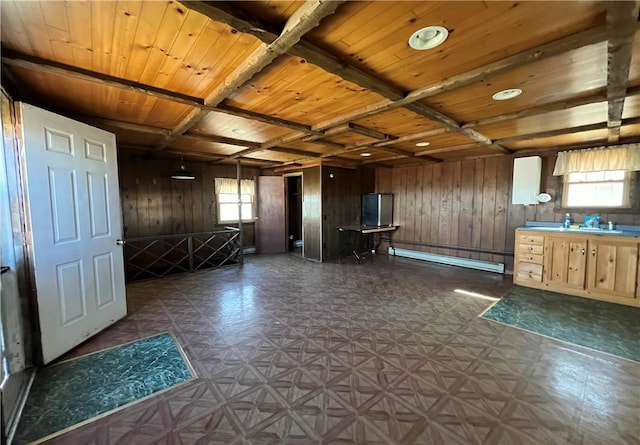 interior space featuring wooden walls, baseboard heating, wooden ceiling, and dark floors