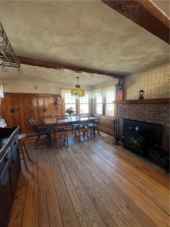 dining area with hardwood / wood-style floors and wallpapered walls