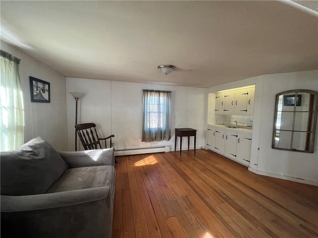 living room featuring a baseboard heating unit and dark wood-type flooring