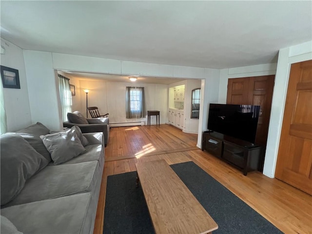 living room featuring a baseboard heating unit and light wood-style floors