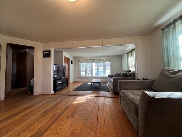 living area with baseboard heating and light wood-style flooring