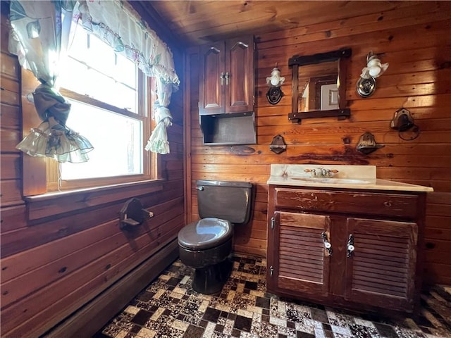 bathroom featuring vanity, toilet, and wood walls