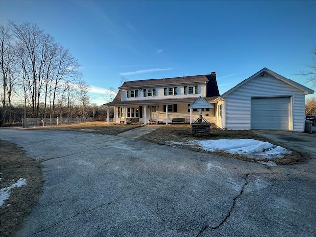 view of front of home with aphalt driveway, a porch, and a chimney