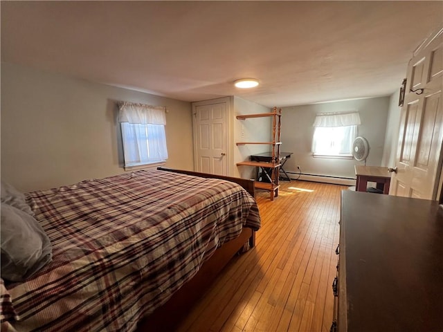 bedroom featuring light wood-type flooring and baseboard heating