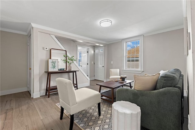 living area with stairway, light wood-style flooring, baseboards, and ornamental molding