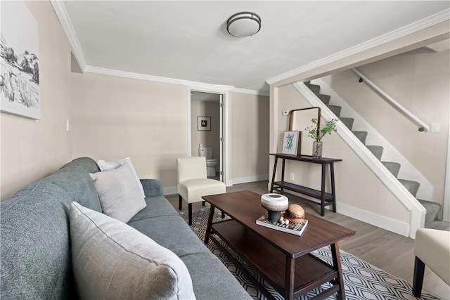 living room featuring wood finished floors, stairs, baseboards, and ornamental molding