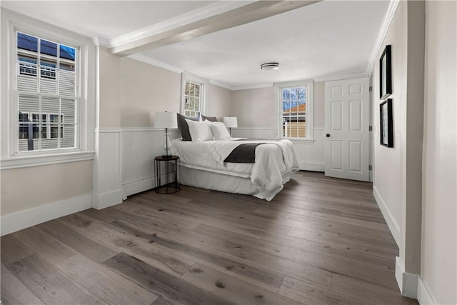 unfurnished bedroom with a wainscoted wall, wood finished floors, and crown molding