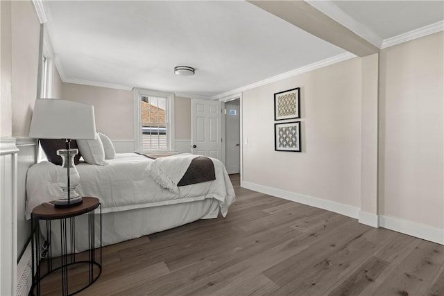 bedroom with ornamental molding, baseboards, and wood finished floors