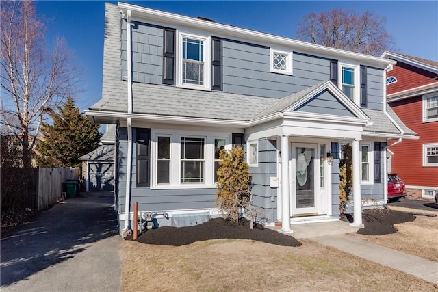 view of front of home featuring a shingled roof and fence