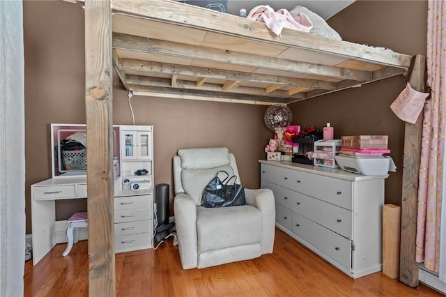 bedroom featuring beam ceiling and light wood finished floors