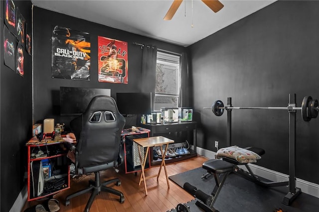 home office with a ceiling fan, wood finished floors, and baseboards