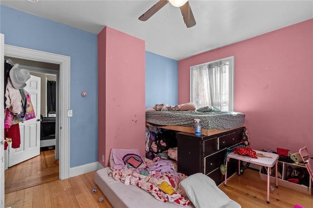 bedroom with baseboards, wood-type flooring, and a ceiling fan