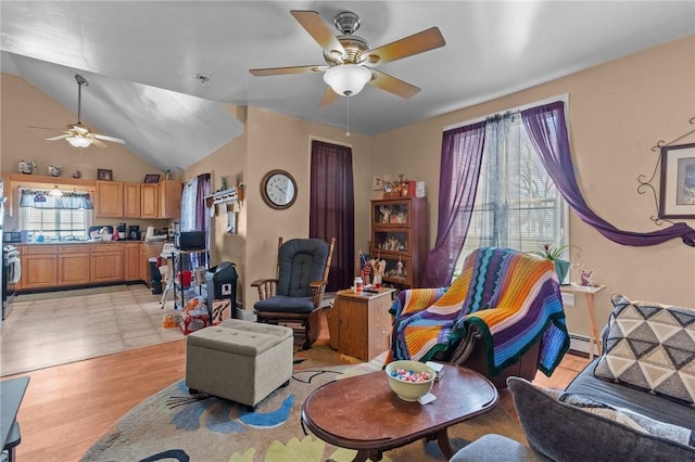 living room featuring light wood-type flooring, a ceiling fan, and vaulted ceiling