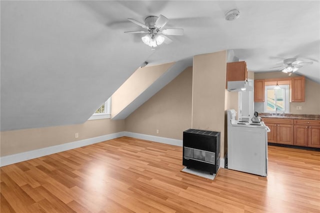 bonus room featuring heating unit, baseboards, a healthy amount of sunlight, and light wood finished floors