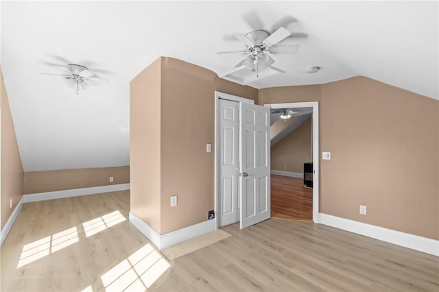 bonus room featuring lofted ceiling, wood finished floors, baseboards, and ceiling fan